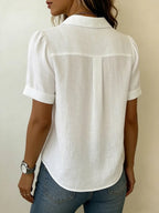 Back view of the white linen blouse showing puff sleeves, collar and box pleat detail across the shoulders