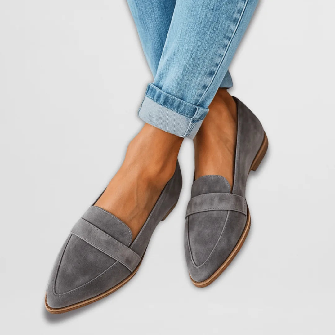Grey suede pointed-toe loafers with penny strap, shown on feet with light-wash cuffed jeans