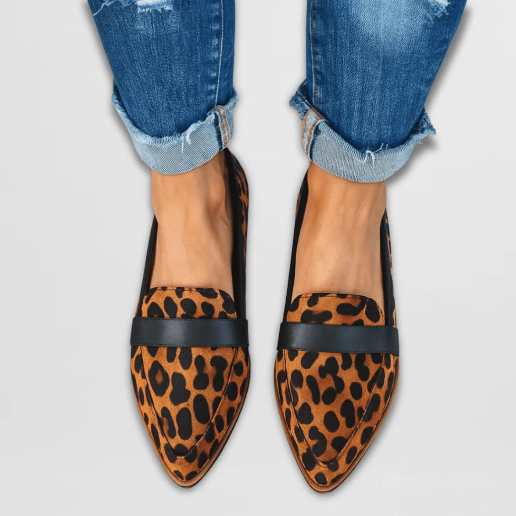 Leopard-print calf-hair pointed-toe loafers with black strap trim, worn with cuffed denim jeans