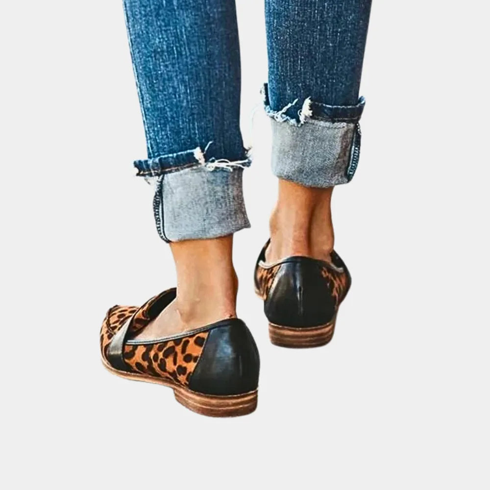 Back view of leopard print pointed loafers with black trim, styled with cuffed skinny jeans