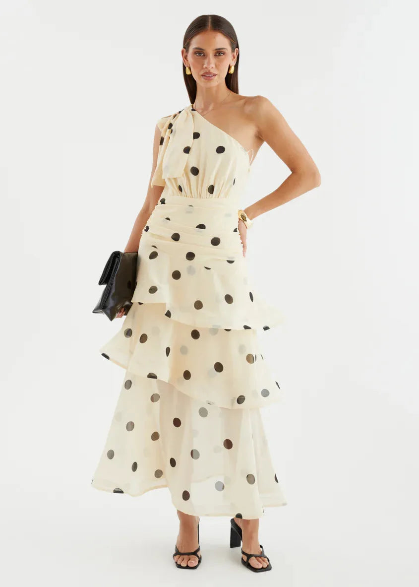 Full-length front view showing the ruched waist and layered ruffle tiers of the polka dot one-shoulder dress