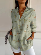 Sage green button-up blouse with a delicate floral vine print, styled with the sleeves rolled up
