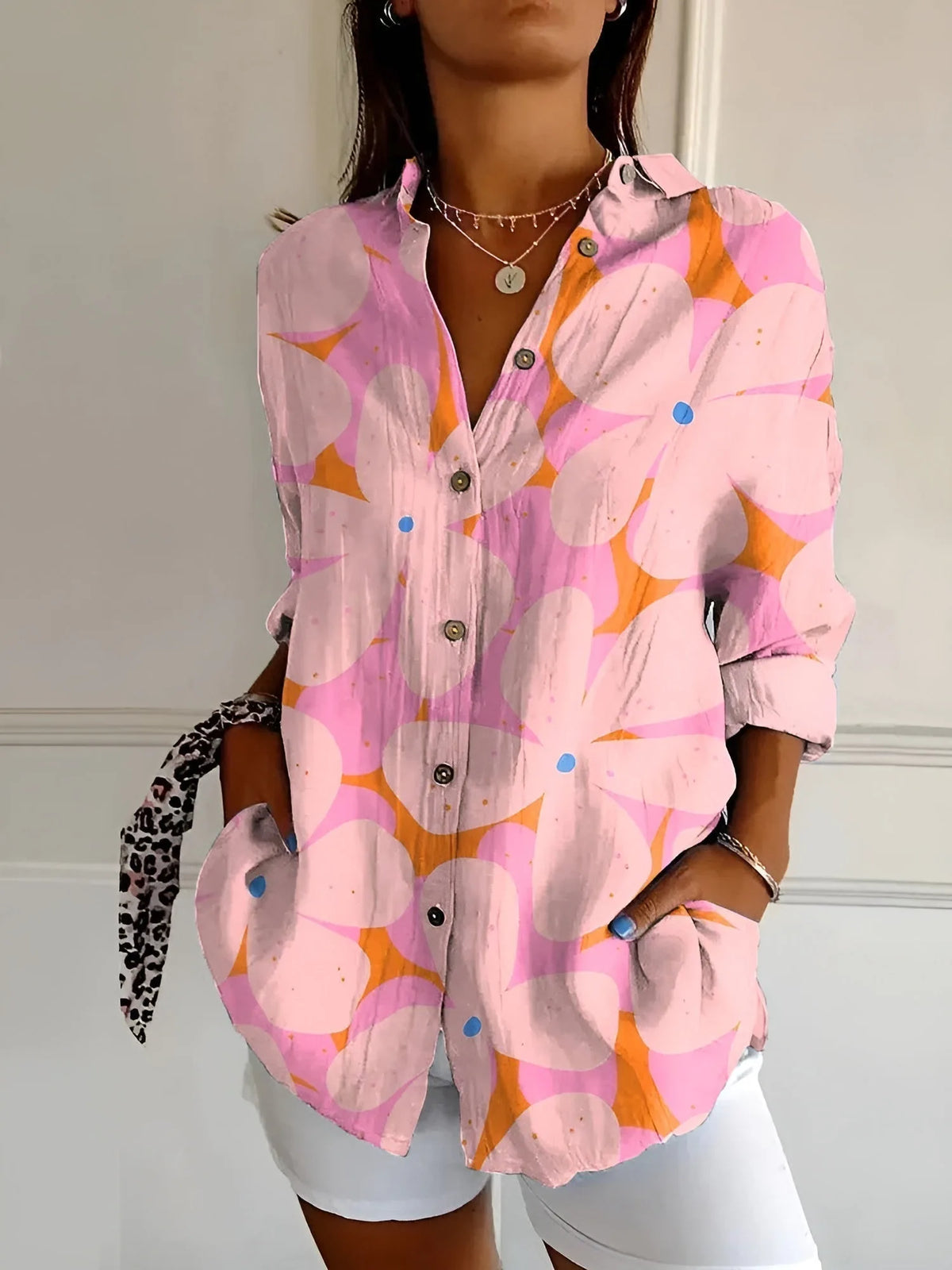Pink and orange blouse featuring a bold abstract flower print with blue accent dots on each petal