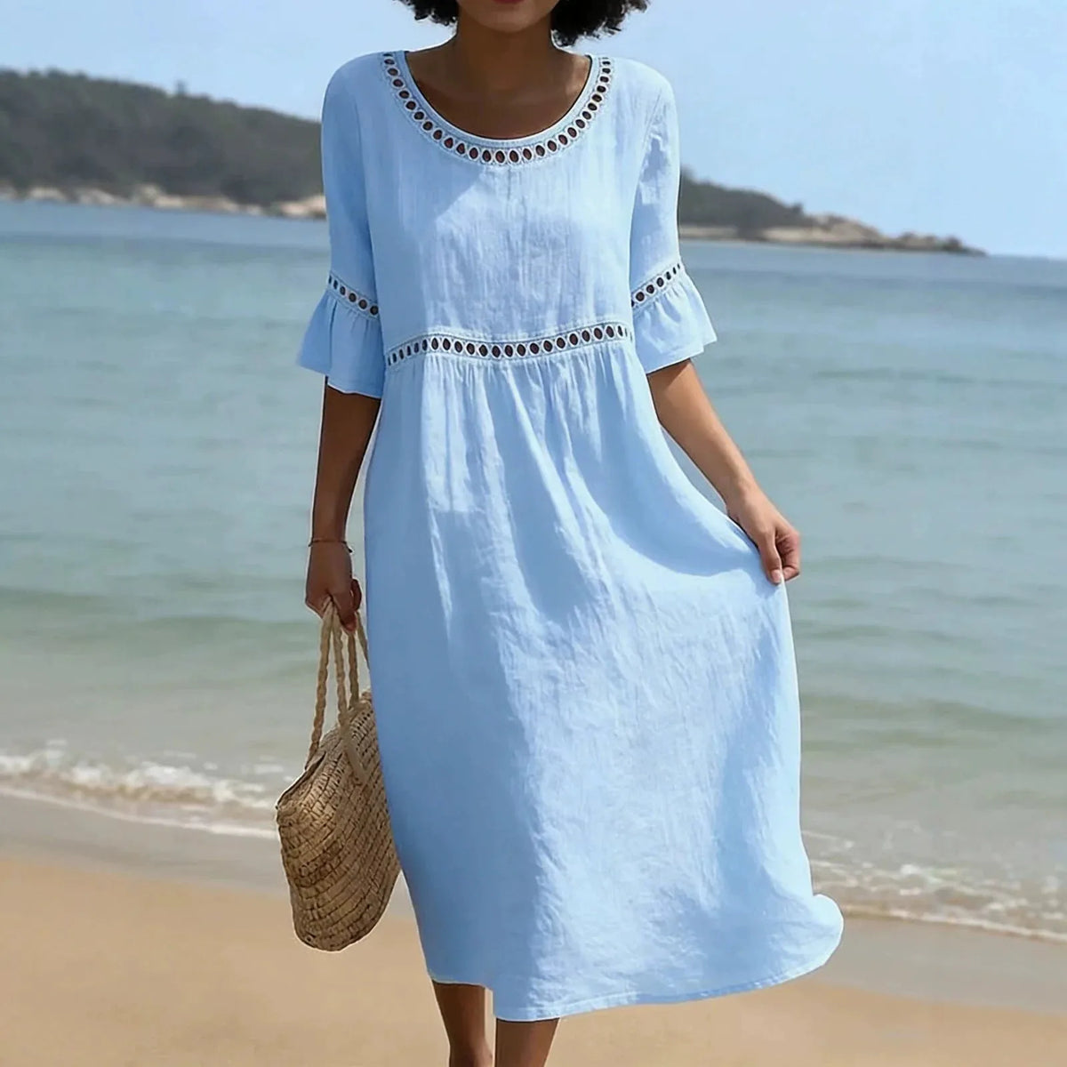 Front view of a model in a pale blue midi dress with crochet-style cutout detail at the neckline and waist