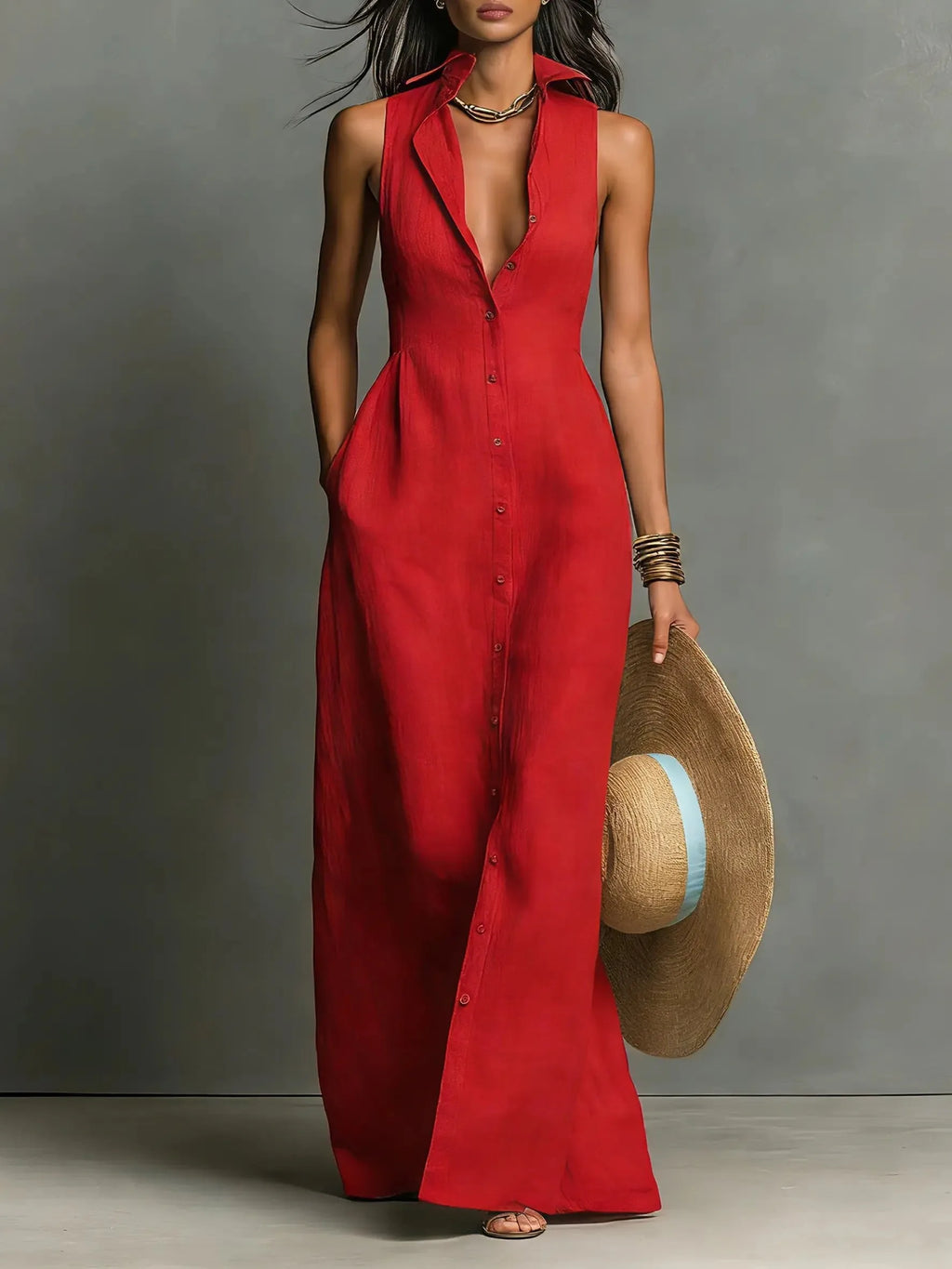 Front view of a sleeveless red collared maxi dress with button-front closure, worn with a straw hat