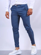 Side view of slim fit chino pants in blue twill, worn with white shirt and white sneakers