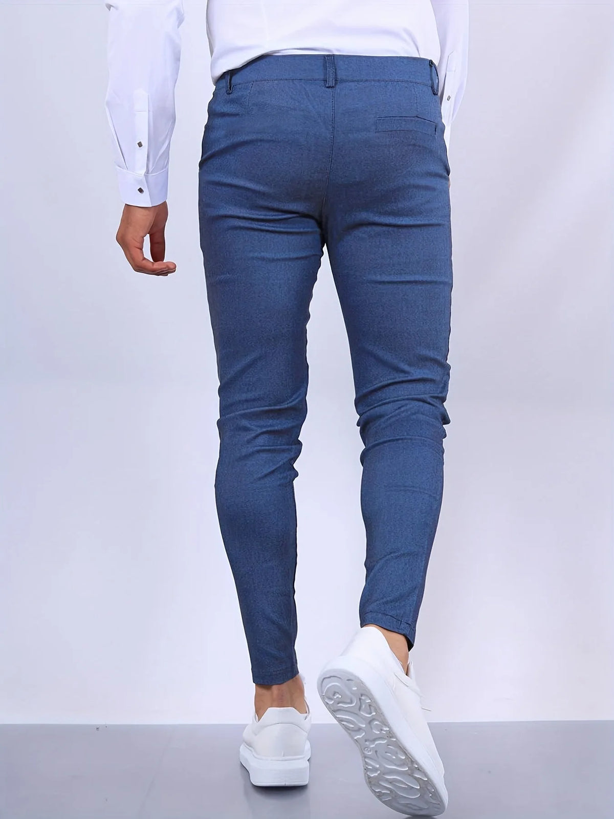 Back view of slim fit blue chino pants showing tailored seat and tapered leg to the ankle