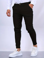Side view of black slim fit chino pants with hand in pocket, paired with white shirt