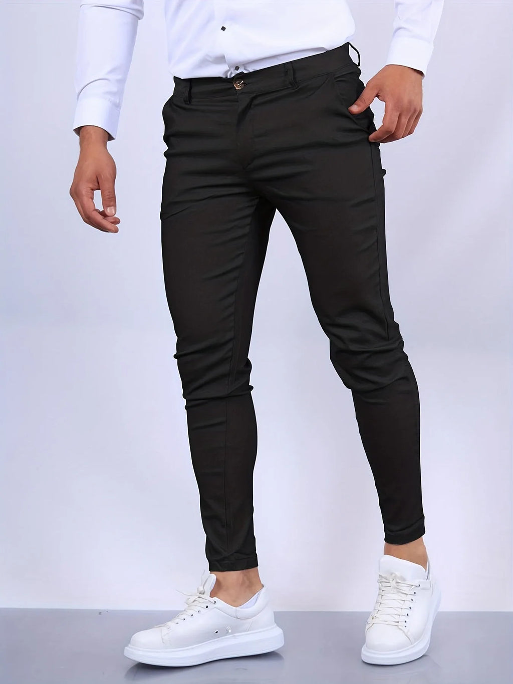 Close-up front view of black slim fit chinos showing waistband, button fastening and pocket detail