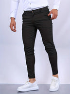 Close-up front view of black slim fit chinos showing waistband, button fastening and pocket detail