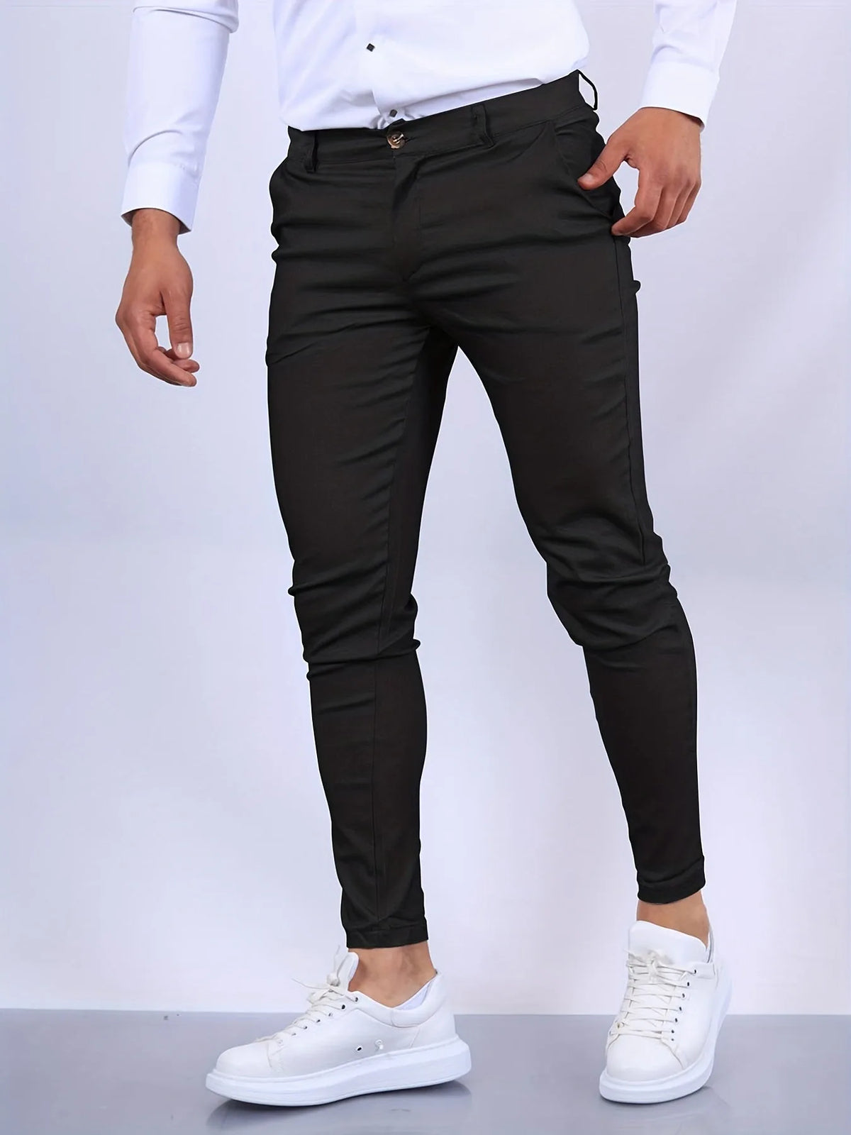 Close-up front view of black slim fit chinos showing waistband, button fastening and pocket detail