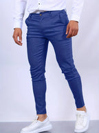 Side view of royal blue slim fit chino pants with tapered ankle length and white sneakers
