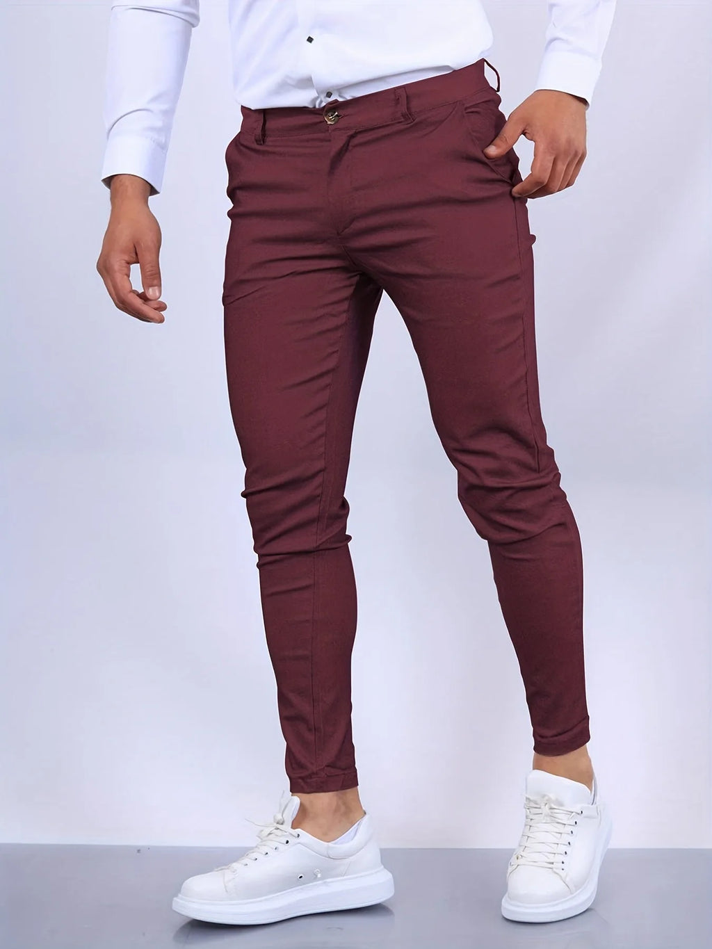 Side view of burgundy slim fit chino pants with hand in pocket, tapered leg silhouette