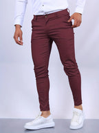Side view of burgundy slim fit chino pants with hand in pocket, tapered leg silhouette