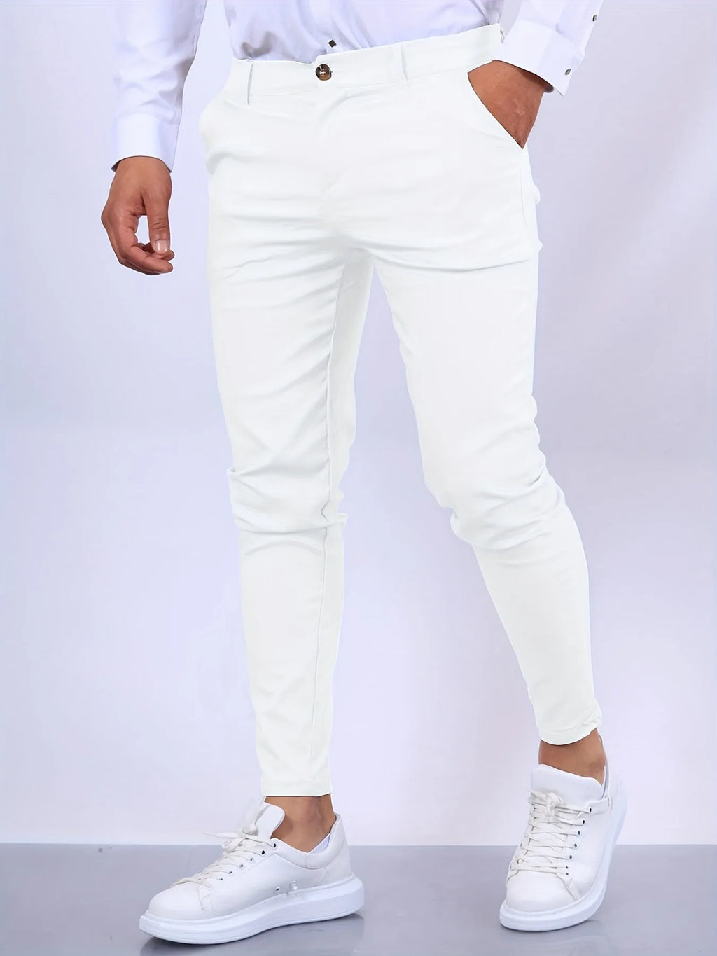 Front view of white slim fit chino pants worn with white shirt and white sneakers