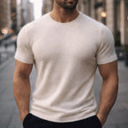 Man wearing a cream coloured short-sleeve knit tee with visible soft, fuzzy knit texture