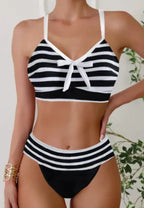 Black and white striped bikini with bow-tie front detail, white trim and high-waisted bottoms, front view.