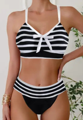 Black and white striped bikini with bow-tie front detail, white trim and high-waisted bottoms, front view.