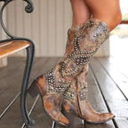 Side view of brown leather studded knee-high western boots with pointed toe and stacked block heel
