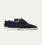 Rear-angled view of navy suede lace-up shoes showing the heel seam and cream outsole
