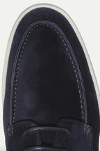 Close-up of the moc-toe stitching detail and suede texture on the navy shoe's toe