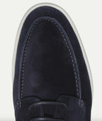 Close-up of the toe stitching and lace eyelets on a navy suede shoe