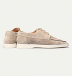 Angled view of beige suede lace-up shoes highlighting the tan leather lining and laces