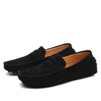 Black suede loafers shown from a three-quarter angle highlighting the sleek low-profile silhouette