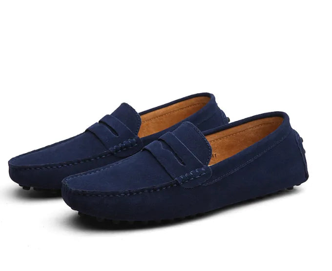 Marine blue suede loafers photographed close up showing the fine suede nap and stitched edges