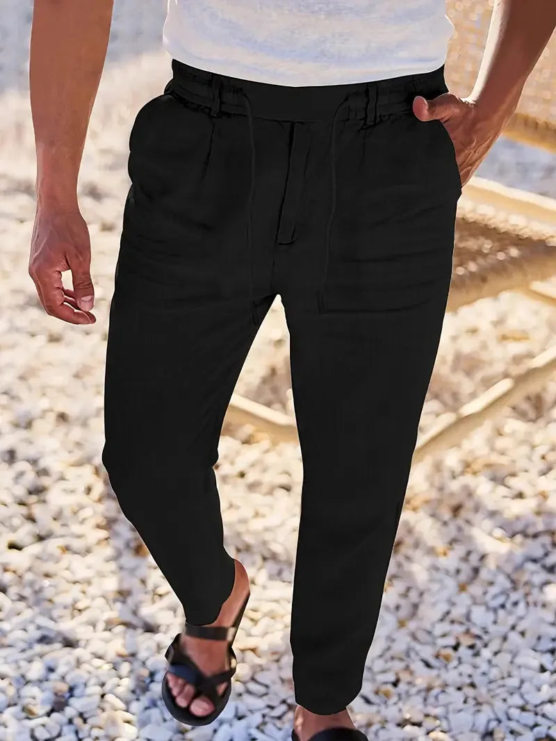 Front view of black linen-blend tapered pants showing smooth fabric and drawstring waist detail