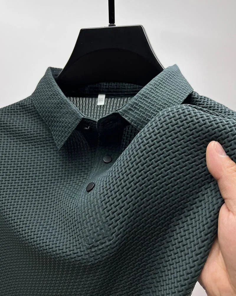 Dark green textured polo shirt close-up, showing collar, placket buttons and woven fabric texture on shoulder
