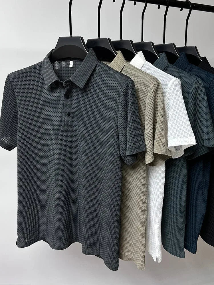 Six textured polo shirts in grey, beige, white, dark green and navy hanging together on a rail, front view