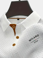 Close-up of a white textured woven polo shirt on a mannequin, showing tan button placket and collar detail