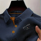 Navy blue textured polo shirt on hanger highlighting tan button detail and structured collar shape