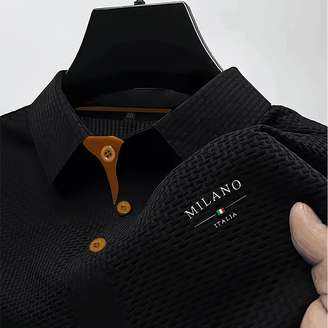 Black textured polo shirt close-up showing woven fabric depth and tan contrast buttons on placket
