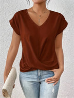 Rust brown V-neck top showing the soft draped twist detail at the waist and relaxed cap sleeve fit