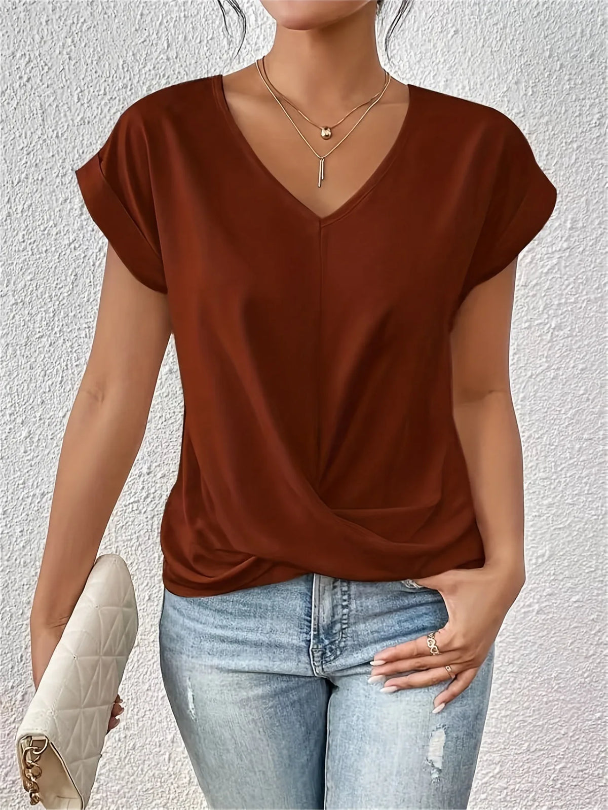 Rust brown V-neck top showing the soft draped twist detail at the waist and relaxed cap sleeve fit