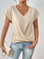 Beige V-neck top showing the centre seam detail and soft fabric drape across the front