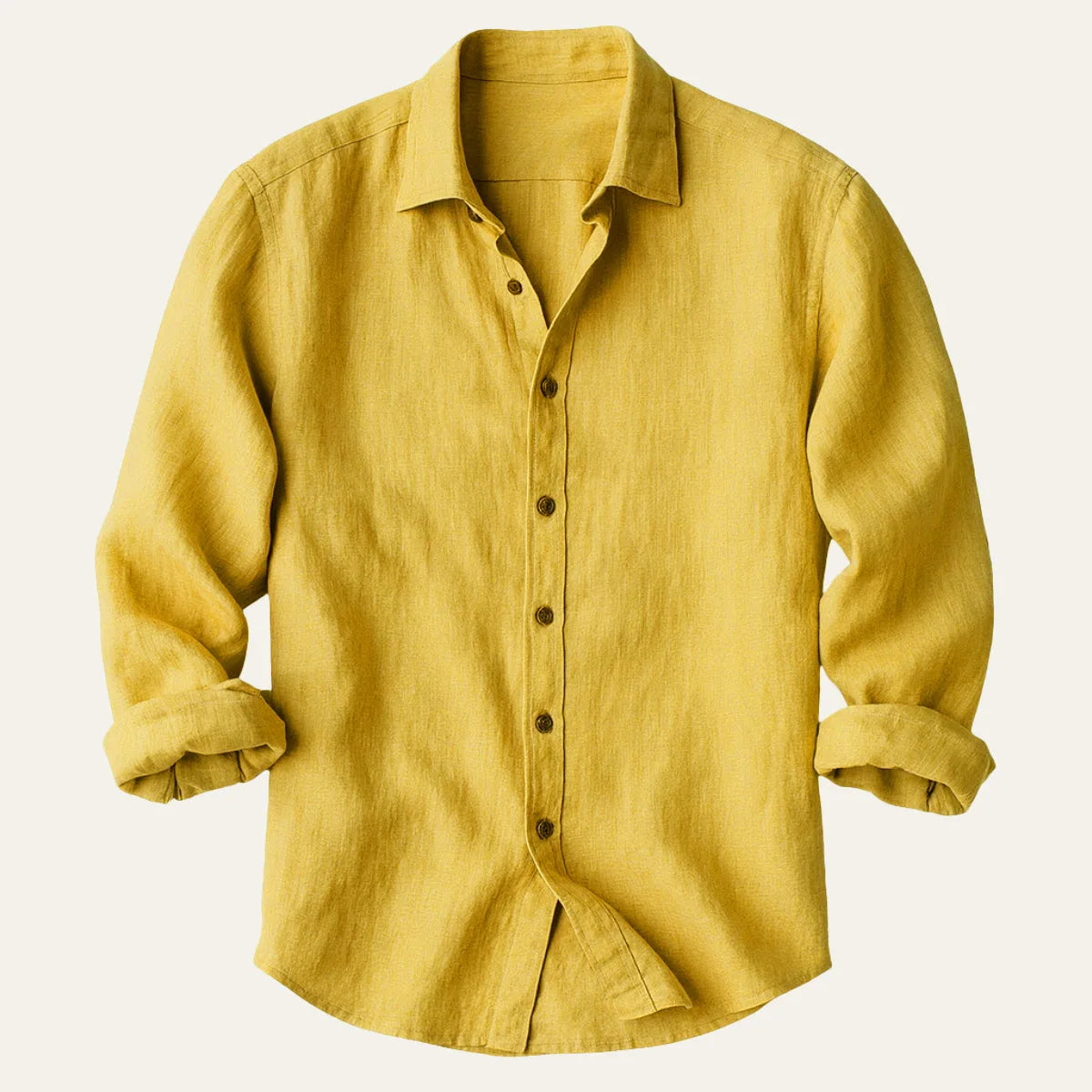 Yellow linen shirt folded flat with sleeves rolled, showing button-down front