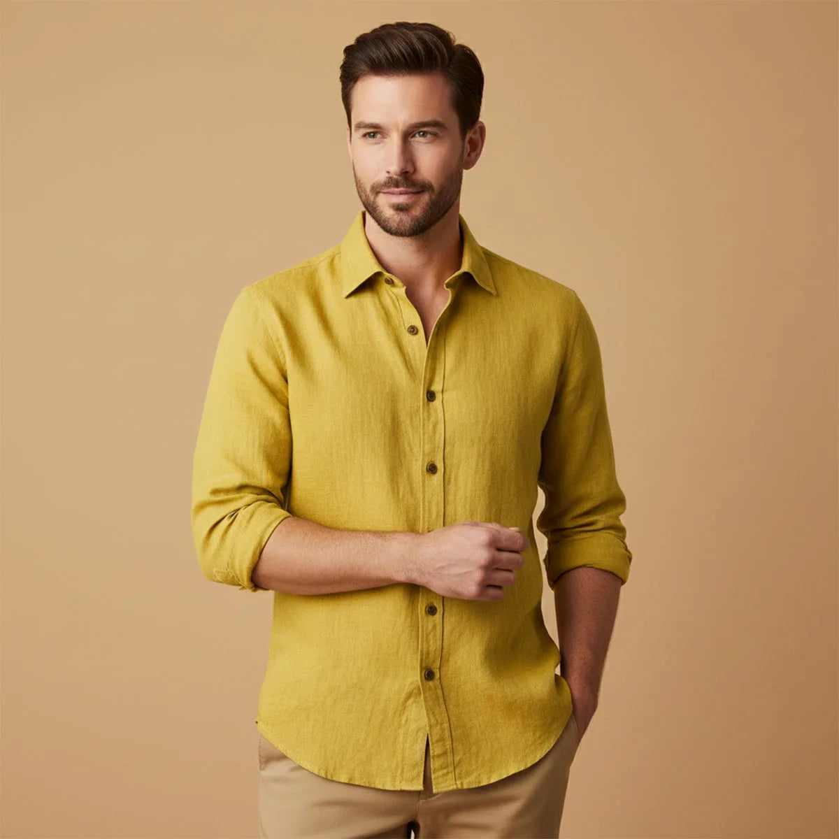 Man wearing mustard yellow linen shirt tucked in with sleeves rolled to the forearm