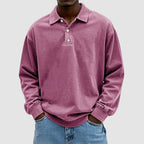Dusty pink washed long-sleeve polo shirt with classic collar and two-button front, worn with blue jeans