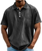 Front view of man wearing a black acid-washed polo shirt with button placket and collar, short sleeves
