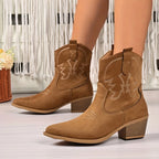 Side view of light brown suede western ankle boot with embroidered stitching and stacked block heel, worn on a model