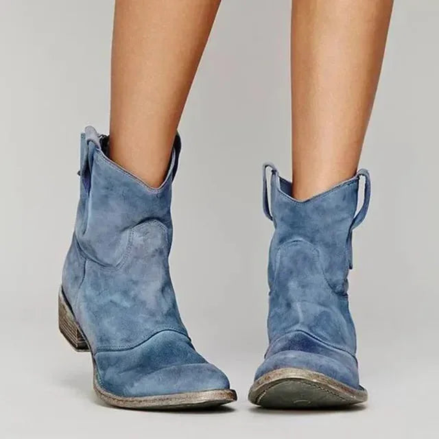 Black suede western-style ankle boots viewed from the front, showing the pointed toe and side pull tabs.