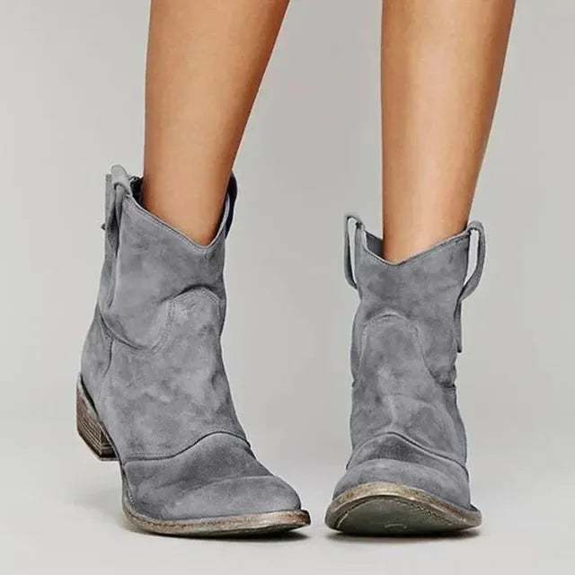 Back view of black suede ankle boots showing the distressed heel and curved vintage-style shaft.