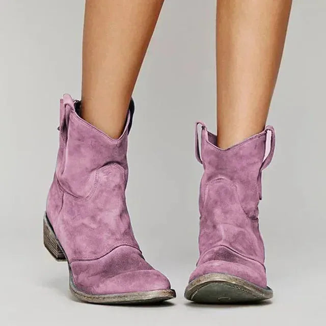 Blue suede western ankle boots photographed from the front, showing the stitched panel and rounded toe.