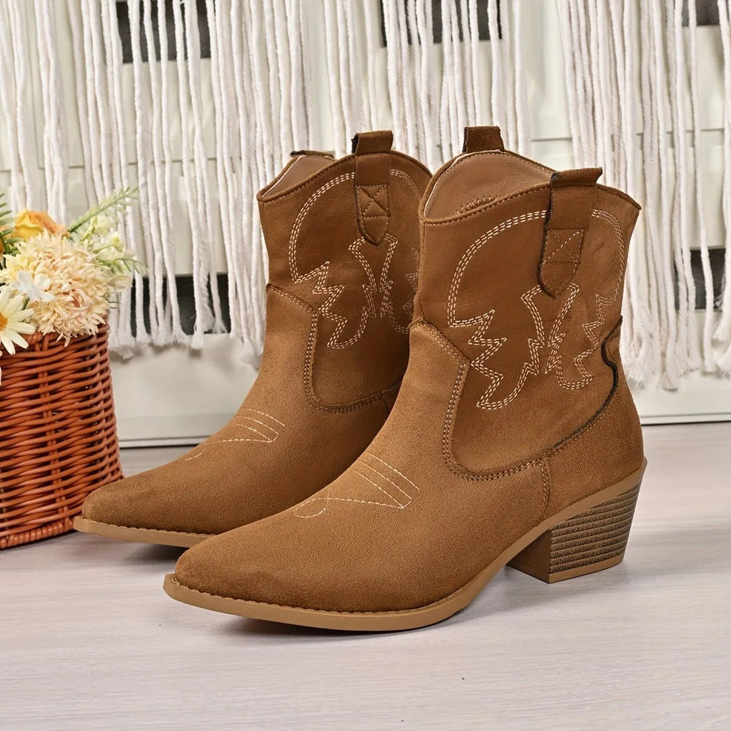 Close-up pair of black suede western ankle boots with embroidered shaft stitching and pull tabs, standing upright