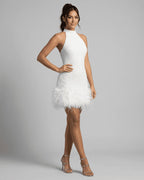 Side profile showing the fitted sequin bodice and fluffy feather trim paired with strappy silver heels