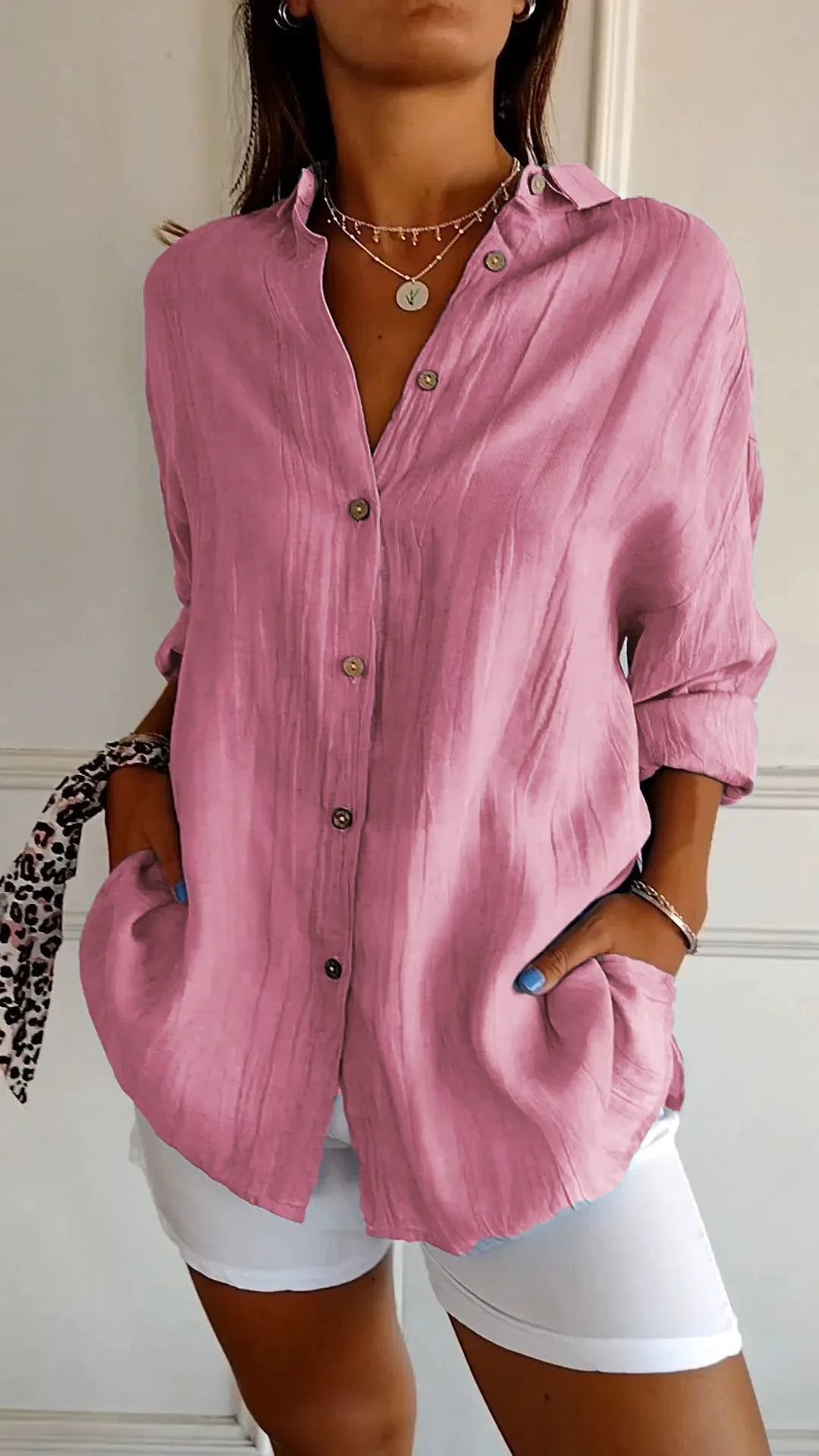 Dusty pink linen shirt fully buttoned with pointed collar, shown with hand resting in the side pocket