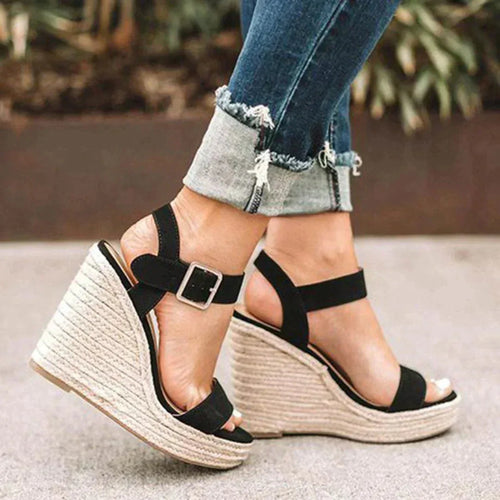 Side profile of black suede espadrille wedge sandals with buckled ankle strap, shown on jute-wrapped platform heel